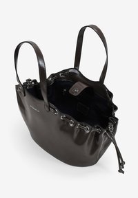 Bolso de cuero marrón oscuro con dos asas, cierre de cordón ajustable y bolsillo interior con cremallera, abierto para mostrar el forro azul marino.