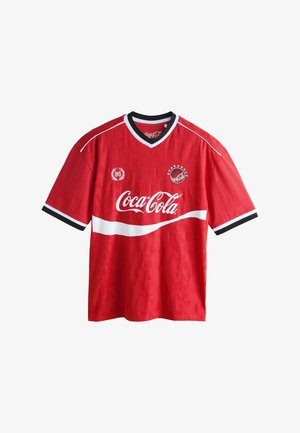 Červený športový dres s krátkym rukávom s bielymi a čiernymi lemami, logo Coca-Cola vpredu a malý emblém s hviezdami na hrudi.