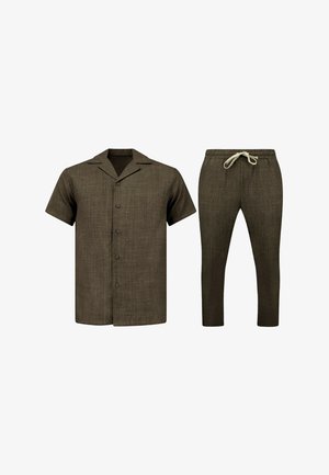 Bruine korte mouwen overhemd met knopen gecombineerd met bruine broek met trekkoord, beide gemaakt van gestructureerde stof tegen een witte achtergrond.