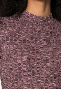 Top ajustado feito de tecido texturizado com um padrão rosa e escuro, com um decote alto e detalhes canelados.