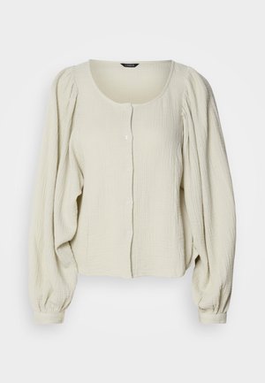 Light beige blouse made of textured fabric, featuring a round neckline, button front, and puffed long sleeves with gathered detailing.