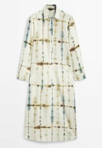 Pitkä nappikiinnitteinen mekko, joka on valmistettu kevyestä kankaasta. Mekossa on vaalea pohjaväri ja ruskeita sekä sinisiä kraklee-kuvioita, pitkät hihat ja kaulus.