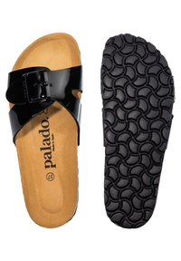 Sandales à glissière noires en vernis avec une boucle, dotées d'une semelle en liège et d'une semelle extérieure en caoutchouc texturé avec un motif en vagues pour une meilleure adhérence. Nom de la marque visible à l'intérieur.