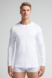 Langmouw wit shirt gemaakt van gladde stof, met een ronde hals en een aansluitende silhouet, gecombineerd met witte slips.