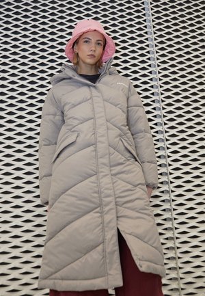 Gray puffer coat with chevron stitching, front pockets, and a zip closure, worn with a pink bucket hat against a textured background.