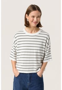 Hvid stribet t-shirt med grønne vandrette linjer, korte ærmer og rund halsudskæring, lavet af et blødt stof. Båret med blå jeans.
