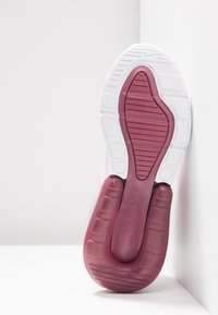 Air Max sneaker sole, featuring a pink rubber outsole with grooves and white accents, textured for traction, showing a rounded shape.