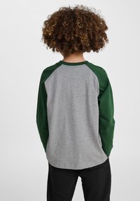 Langermige t-shirt met een grijs lichaam en groene raglanmouwen. Zachte katoenmaterialen, relaxed fit, ronde halslijn en geen zichtbare patronen.