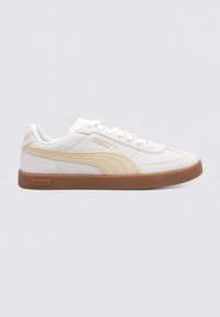 Zapatilla blanca y beige con parte superior texturizada, que cuenta con una suela de goma, diseño de cordones y marca PUMA en el lateral.