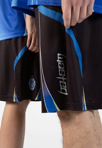 Crne sportske tajice s plavim i zelenim naglascima, s logotipom i tekstom na nozi. U paru s plavim majicom.
