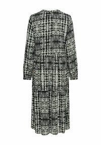 Schwarz-weiß gemustertes Kleid mit langen Ärmeln, runder Halslinie und fließender Silhouette. Der Stoff hat ein strukturiertes, abstraktes Design.