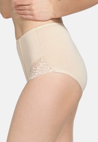 Mutande beige a vita alta con una texture liscia e pannello in pizzo sul lato, caratterizzate da una vita ondulata e dettagli cuciti.