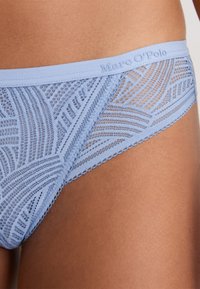 Hellblauer Spitzenunterwäsche an Taille und Hüfte, mit geometrischen Mustern und einem Bündchen mit "Marc O'Polo"-Markenlogo.