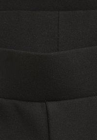 Svart elastisk midjeband med en slät textur och en sömdetalj. Designad för komfort och flexibilitet, lämplig för träningskläder.