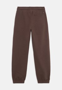 Pantalones de chándal marrones con cintura elástica y tobillos ajustados, y un único bolsillo trasero que presenta un pequeño logo de Tommy Hilfiger.