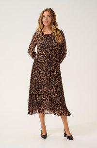 Ruskean ja mustan valkoisen leopardikuosiset pitkät hihat mekko, jossa on laskostettu hame ja pyöreä pääntie. Slim-fit malli, jossa sivutaskut; yhdistetty mustiin korkokenkiin.