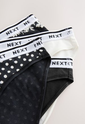 Lot de trois culottes pour femmes présentant un mélange de couleurs noir et blanc, des pois, un motif floral, et des tailles élastiques avec le logo de la marque.
