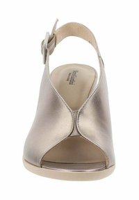 Scarpa slingback aperta in oro metallico con una finitura liscia, dotata di una vasta fascia e fibbia regolabile per una calzata sicura. Suola piatta.