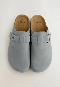 Gray suede clogs with a smooth texture, open back, and adjustable buckle strap. Interior features a tan cushioned footbed.
