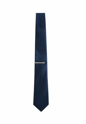 Dark blue textured necktie with a slim silver tie clip placed near the middle on a white background.