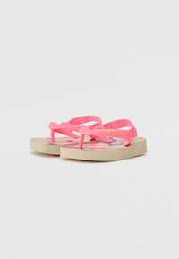 Des tongs roses avec une semelle texturée et des sangles tissées, dotées d'un semelle intérieure à motif coloré et d'un design plat pour une utilisation décontractée.