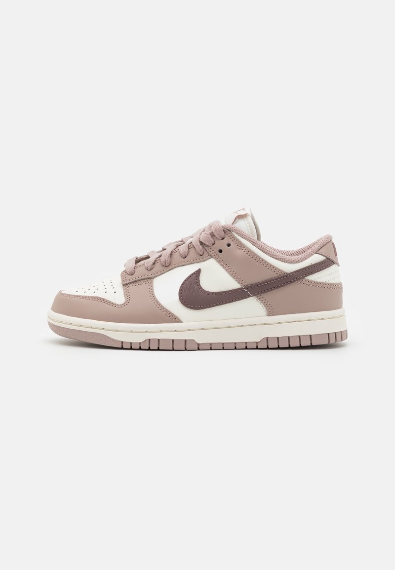 Low-top sneaker in beige and white leather with mauve laces and Swoosh logo, positioned sideways on a plain white background.