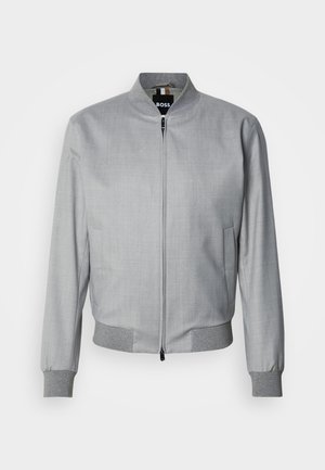 Hellgraue Bomberjacke mit glatter Textur, gerippten Bündchen und Saum, ausgestattet mit einem Front-Reißverschluss und Seitentaschen.