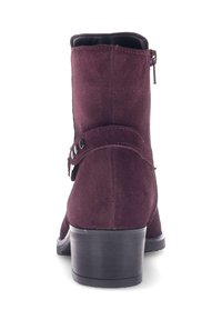 Bordeaux kleurige suède enkellaarzen met een lage hak, een rits aan de zijkant en een decoratieve band met twee metalen studs. Glad binnenvoering.