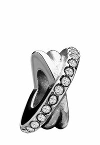 Zilveren ring met een gedraaide design, versierd met ronde heldere edelstenen langs één rand, wat zorgt voor een gestructureerd en reflecterend oppervlak.