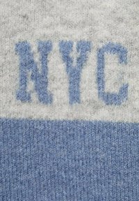 Šedá a světle modrá pletená tkanina s horizontálními pruhy; "NYC" ve světle modré, texturovaný povrch, měkký vzhled.