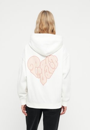 Hoodie bianco con una grande applicazione a cuore rosa chiaro sul retro, accompagnata da testo stilizzato. Realizzato in un tessuto spesso e strutturato con cappuccio.
