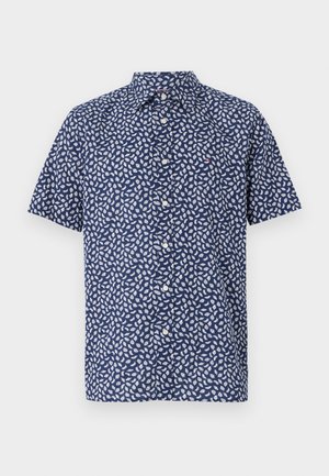 Lyhythihainen paita tummansinisestä kankaan, jossa on valkoinen lehtikuvio, huippukaulus ja nappikiinnitys. Ei näkyviä logoja tai yksityiskohtia.