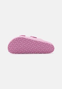 Scarpa slip-on rosa con suola in gomma testurizzata e motivo ondulato. Due cinghie regolabili sulla parte superiore per una calzata sicura.