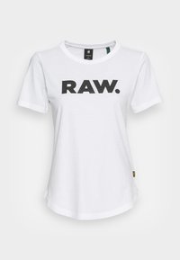 Bílý bavlněný tričko s výrazným černým potiskem "RAW." na přední straně. Má krátké rukávy a kulatý výstřih, s mírně zakřiveným lemem.