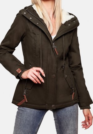 Dunkelgrüne Kapuzenjacke mit weißem Fleecefutter, Reißverschluss und Knopfleiste, Fronttaschen, getragen zu blauen Jeans.