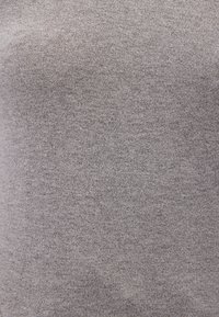 Grauer Strickstoff mit glatter Textur, gleichmäßiger Konsistenz und dezentem Glanz. Leicht und elastisch, geeignet für verschiedene Bekleidungsstücke.