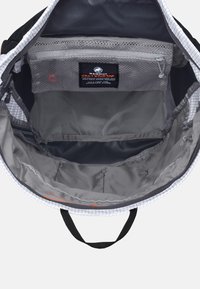 Zwarte rugzak interieur met grijze voering. Bevat een ritsvak, opbergruimtes en een label van Mammut. Textuurdesign van stof.