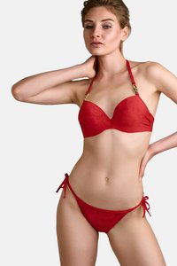Červený bikiny set s formovaným, vycpaným bikinovým topem, který obsahuje dekorační kovové prvky a nastavitelné ramínka. Spodní díl má boční šňůrky a hladký povrch.