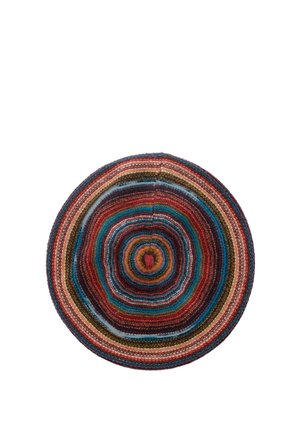 Chapeau rond tissé avec des rayures concentriques en rouge, bleu, marron, orange et beige sur fond blanc.