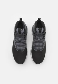 Black and gray athletic shoes with a textured surface, featuring a padded collar, elastic laces, and a white rubber sole.