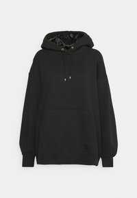 Sudadera negra con un amplio bolsillo frontal, detalles de cordones dorados y una textura interior suave. Diseño oversize con mangas largas.