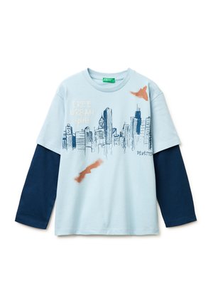 Jasnoniebieska warstwowa koszula z długim rękawem w kolorze granatowym, granatowy nadruk panoramy miasta, tekst "FREE URBAN spirit" oraz małe pomarańczowe plamy farby.