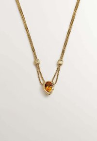 Collar en tono dorado con dos cadenas retorcidas. Presenta un colgante de gema de ámbar en forma de pera enmarcado en un ajuste metálico acanalado.