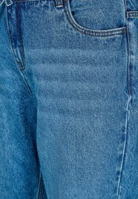 Jeans de mezclilla azul claro con un diseño clásico de cinco bolsillos, costuras en contraste y una textura de tela suave.