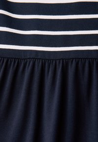 Vestido azul marino con rayas horizontales en blanco y crema en la parte superior; tela texturizada con sección de falda fruncida.