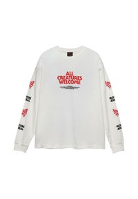 Weißes Langarmhemd mit rotem Schriftzug "ALLE KREATUREN WILLKOMMEN" auf der Brust und schwarzem sowie rotem Schriftzug "STRANGER THINGS" und "MONSTER SIND REAL" auf den Ärmeln.