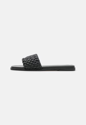 Sort vævet slip-in sandal med en struktureret overdel og flad sål. Har et moderne, minimalistisk design. Ideel til afslappet brug.