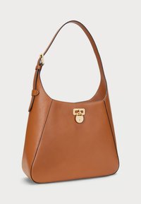 Barna bőr válltáska ívelt formával, arany színű záróelemekkel és kontrasztos fekete varrással a széleken.