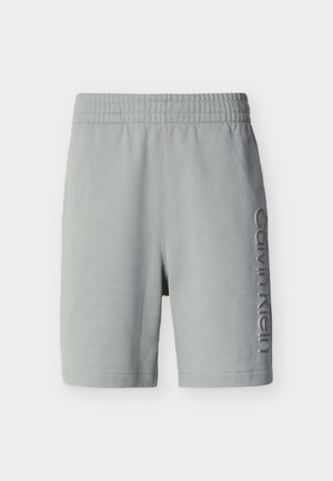 Ανοιχτό γκρι σορτς μέχρι το γόνατο με ελαστική μέση και κάθετο λογότυπο Calvin Klein στο δεξί πόδι.