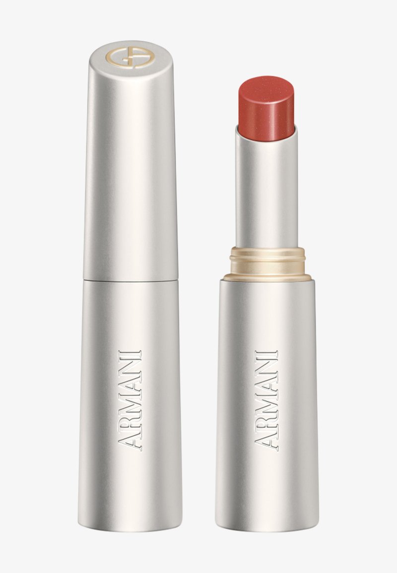 Sølvfarget Armani leppestift-tube med hette ved siden av, som viser en dempet rød leppestift som er trukket ut.